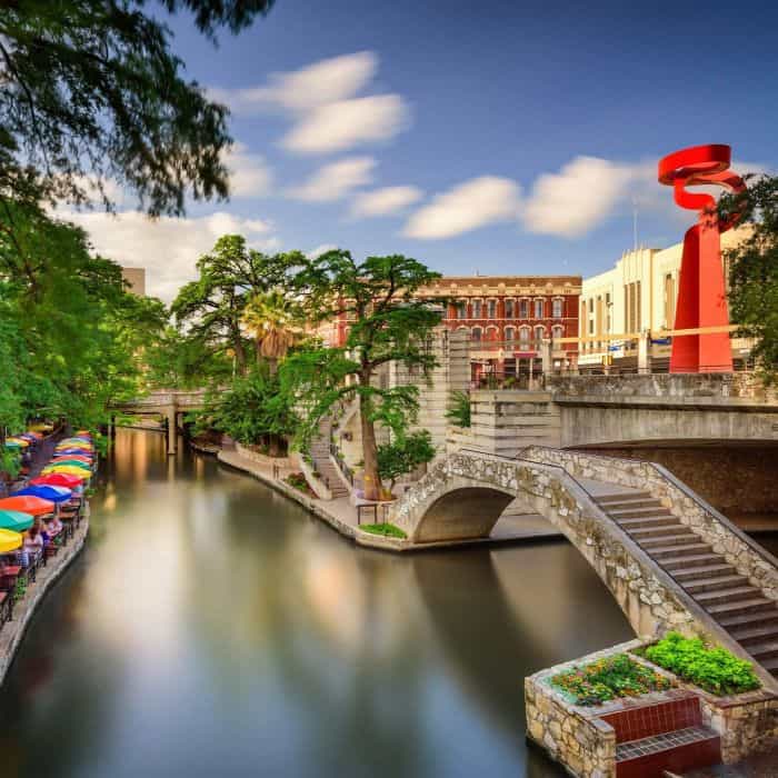 San Antonio River Walk near local hearing clinic with colorful umbrellas and bridge
